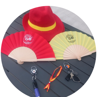 Deux éventails, un rouge et un jaune, accompagnés d'un chapeau rouge et d'accessoires variés.